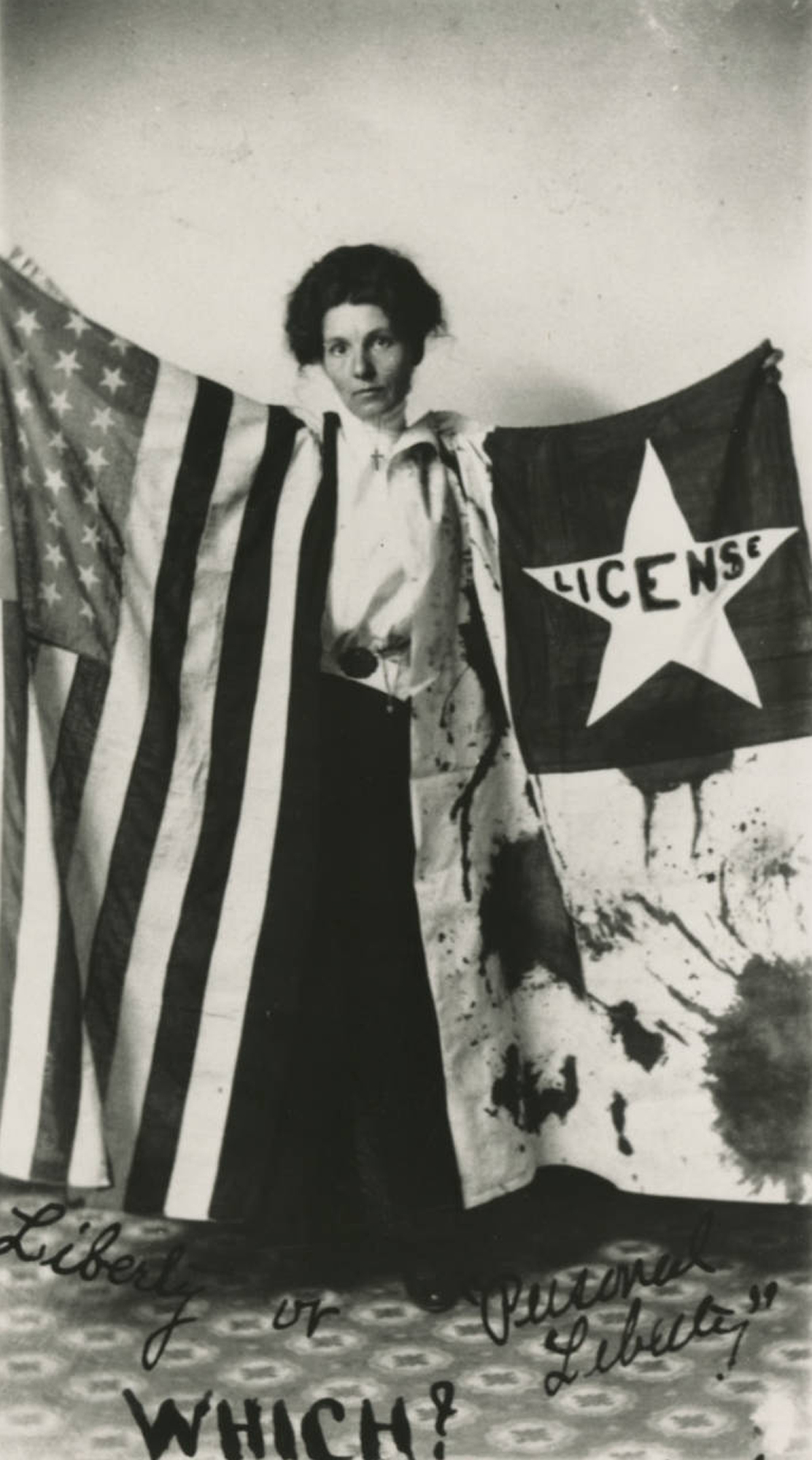 Black and white photograph of Bernie Babcock holding a suffrage banner and an American flag