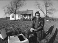 Cash kneels in the backyard of the house he grew up in Dyess, Arkansas, fall 1968