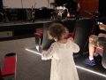 An unidentified  little girl in a white dress on the floor of a theater