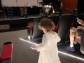 An unidentified  little girl in a white dress on the floor of a theater