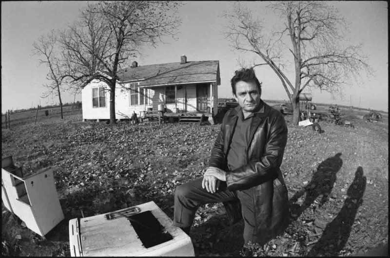 Cash kneels in the backyard of the house he grew up in Dyess, Arkansas, fall 1968
