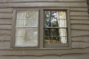 Exterior boards, windows, and window screen on cabin.