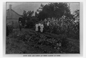 Black and white image of Scott Bond and his family in the garden.