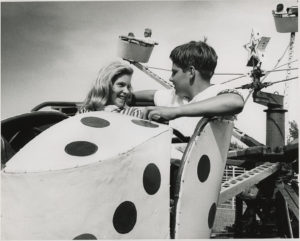 Winthrop Paul Rockefeller with Vikki Smith on carnival ride at Tenth Anniversary of Winrock Farms, 1963 August