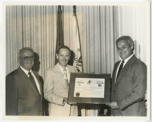 Charles Duke is presented a Arkansas Traveler certificate by Governor Frank White and Max Howell.