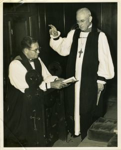 Brown kneeling while unidentified church official appears to bless him.