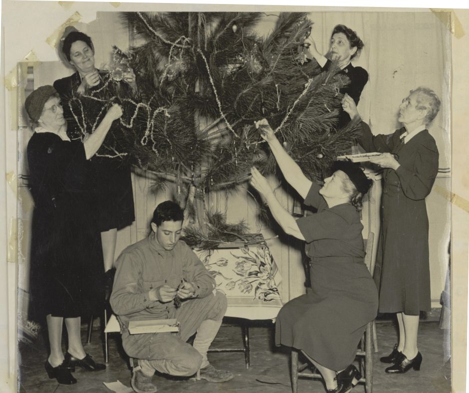 Pauline helping to decorate a christmas tree.