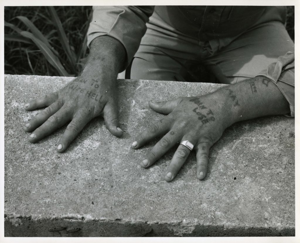 Inmate showing tattoos on hands