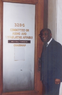 Dr. Townsend in front of the door to the Committee on Aging and Legislative Affairs, ca. 1995