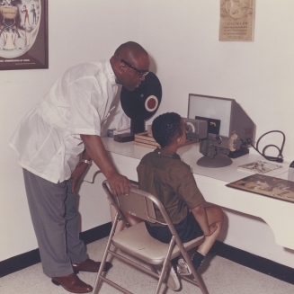 Dr. Townsend gives a vision exam to a boy at his clinic on Wright Ave, early 1980s