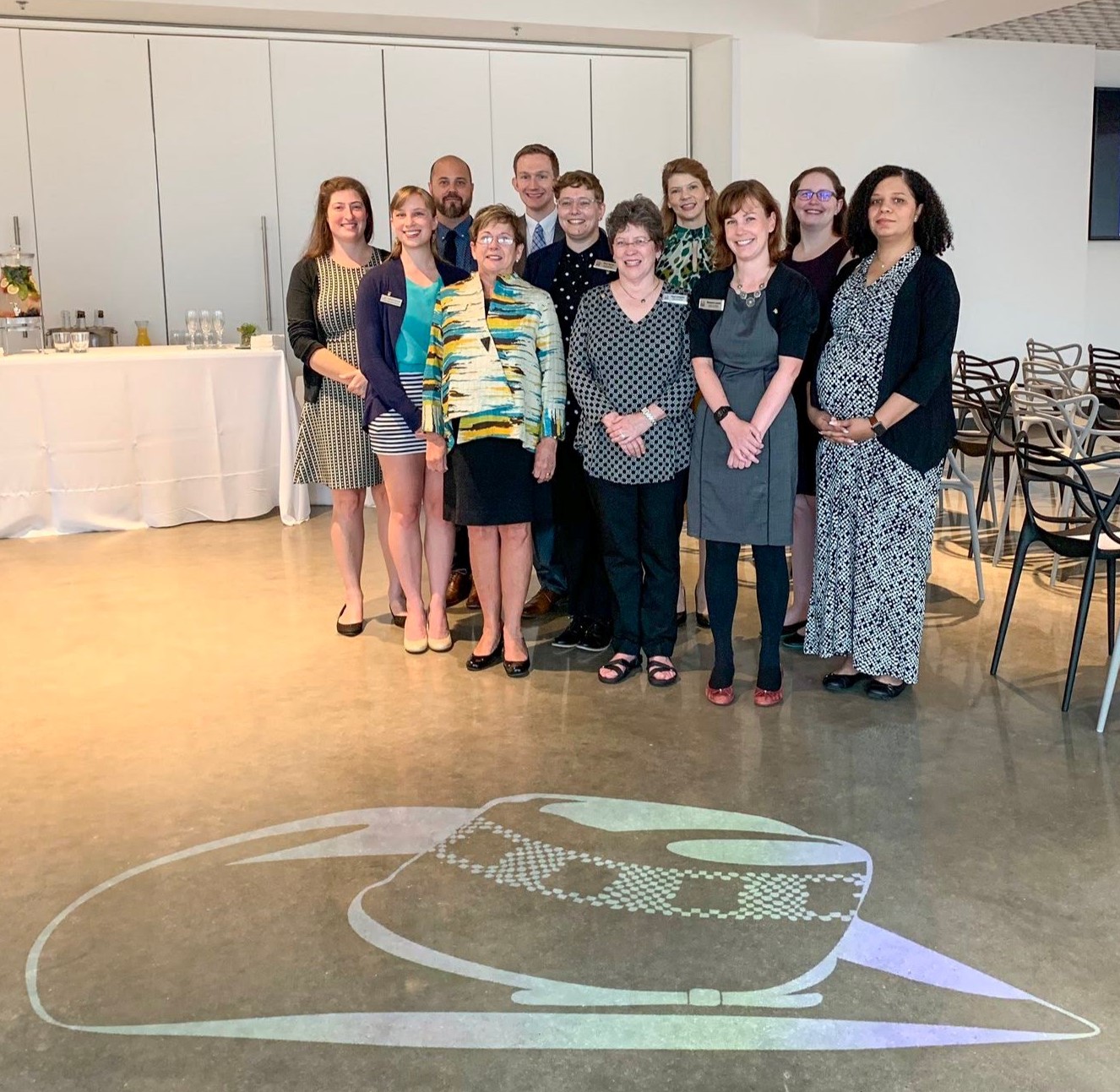 Group photograph of the staff and graduate assistants of CAHC. On the floor in front of them is a projected image of Winthrop Rockefeller's hat.