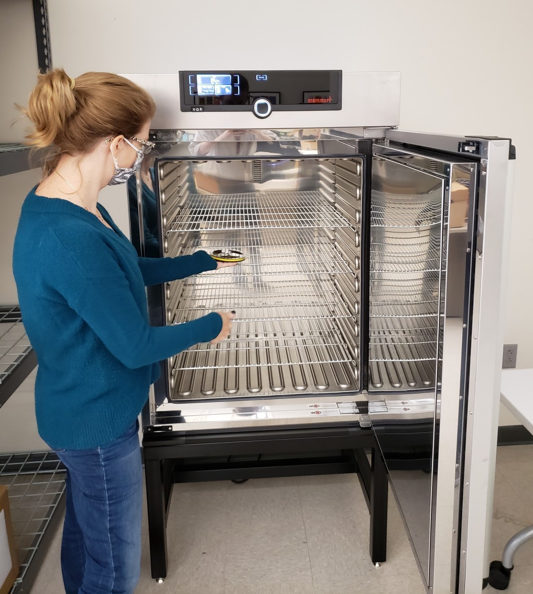 Assistant Director Laura McClellan places an audio reel inside the scientific oven to be baked