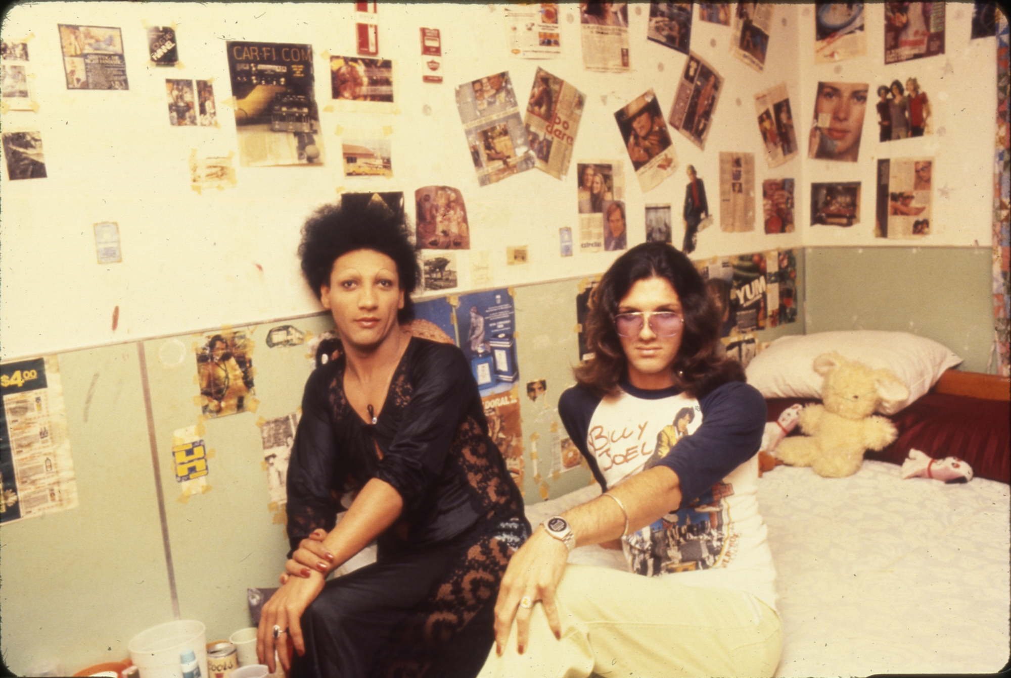 A color photograph of two non-gender conforming individuals in their living quarters at Fort Chaffee.