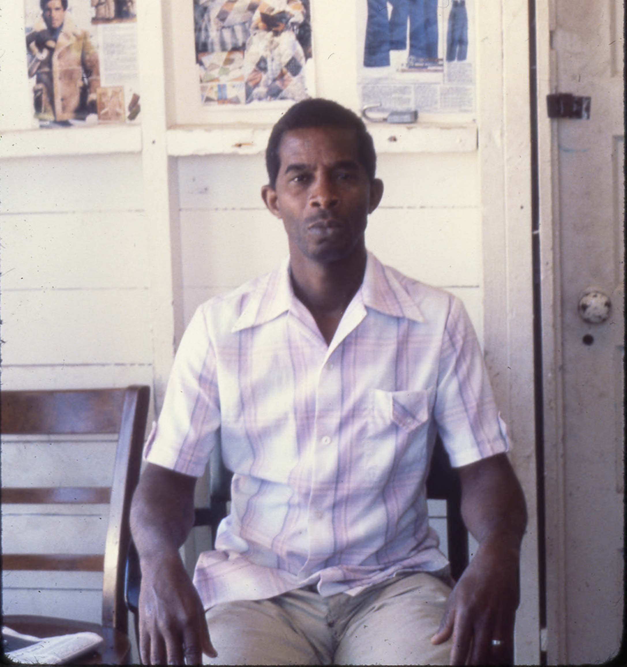 A color photograph of a Cuban refugee sitting.
