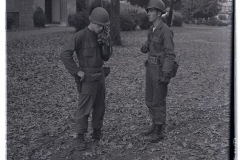 Two 101st Airborne soldiers on patrol, one speaking into radio headset