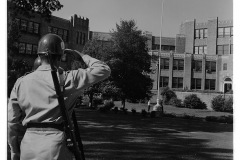 Arkansas National Guardsmen saluting during flag lowering in front of Central High School