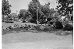 Students sketching Arkansas National Guard troops relaxing on lawn in front of Central High School