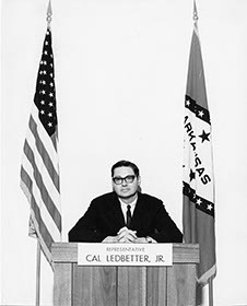 Cal Ledbetter seated at podium, ca. 1969