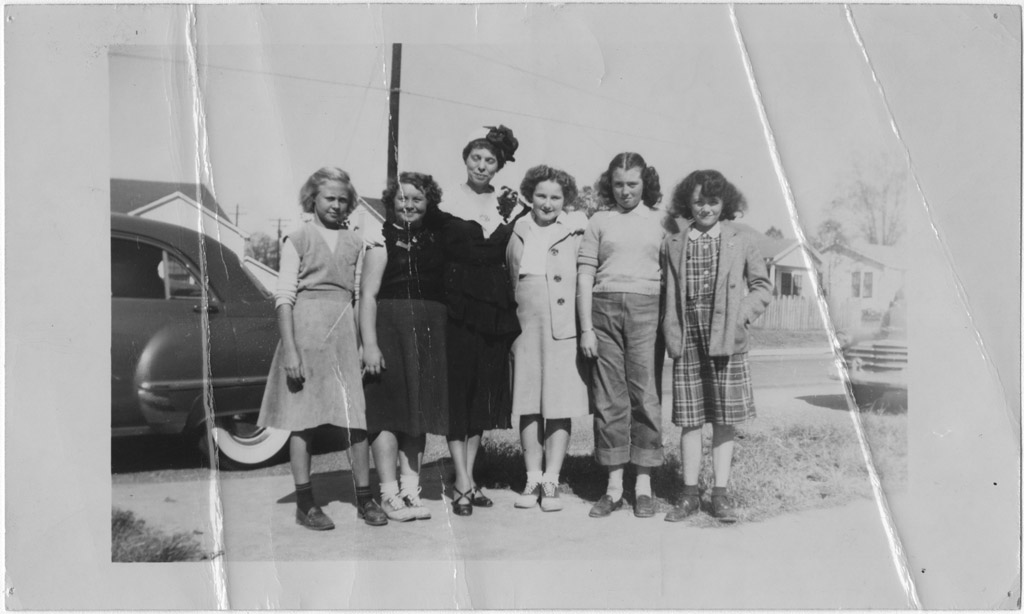  Charlie May Simon pose pour une photo avec cinq étudiantes devant une voiture.