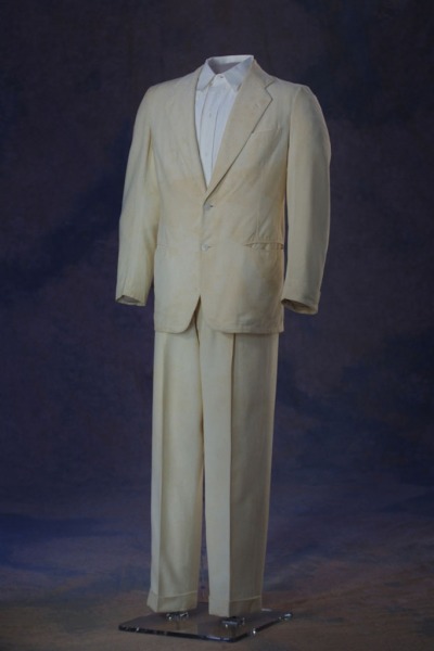 Image of Governor Charles Brough two piece suit in the "Palm Beach" style. The white jacket features two white buttons on the front and on the cuff. The suit is from the campus shop and made by Goodall and Sanford, Inc.