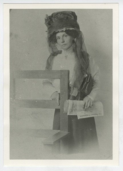 Bernie Babcock posing with temperance newspapers.