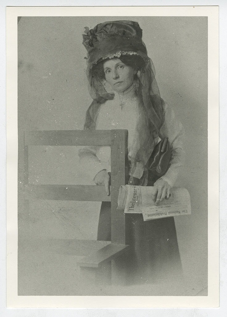 Bernie Babcock posing with temperance newspapers.