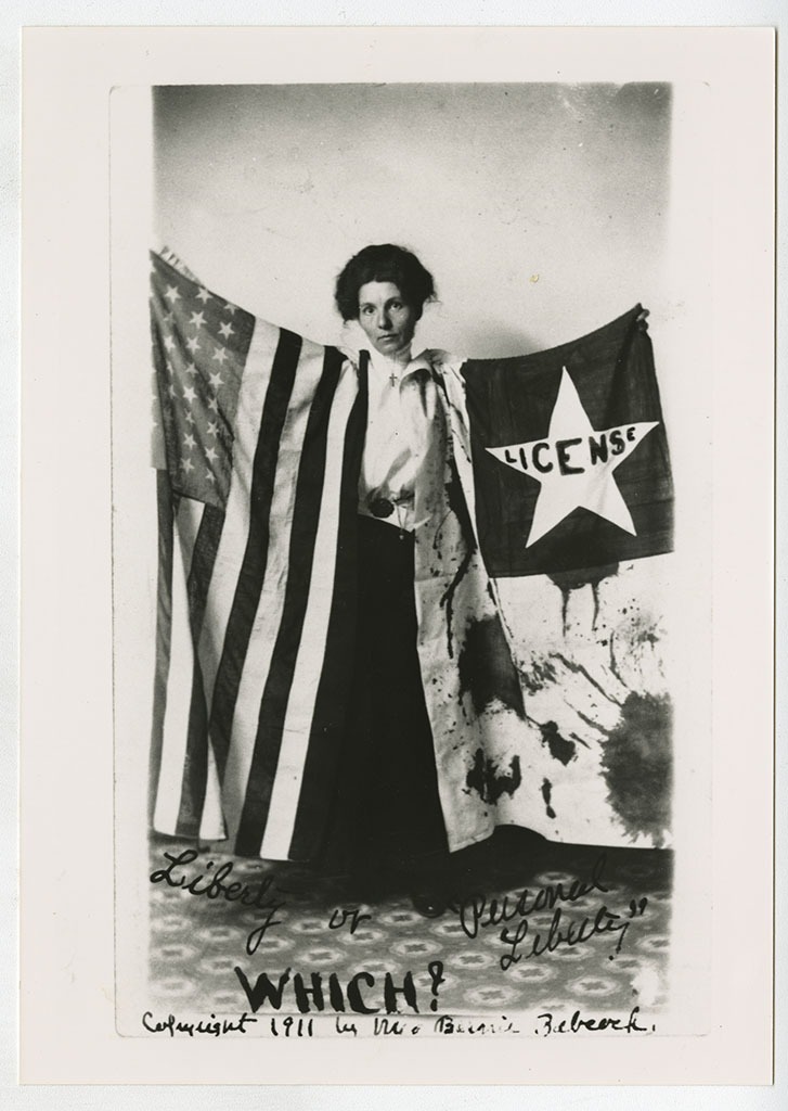 Bernie Babcock holding a suffrage banner and American flag