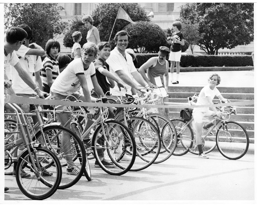 Jim Guy Tucker riding bicycle in race with crowd near Capitol building Jim Guy Tucker riding bicycle in race with crowd near Capitol building