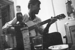 Jim Guy Tucker playing guitar in house in Saigon, Vietnam