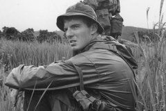 Jim Guy Tucker sits in a field, Vietnam