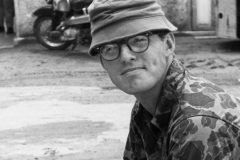 Jim Guy Tucker in unidentified location with gun, Vietnam