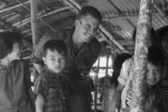 Jim Guy Tucker with Vietnamese children in unidentified village, Vietnam