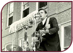Black and white photograph of Johnny Cash singing and playing his guitar at a Gov. Rockefeller campaign event