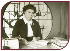 Sepia photograph of Charlie May Simon at a desk reading a book