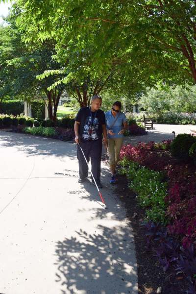 Client learning how to use a white cane outside with O&M staff, 15 October 2021