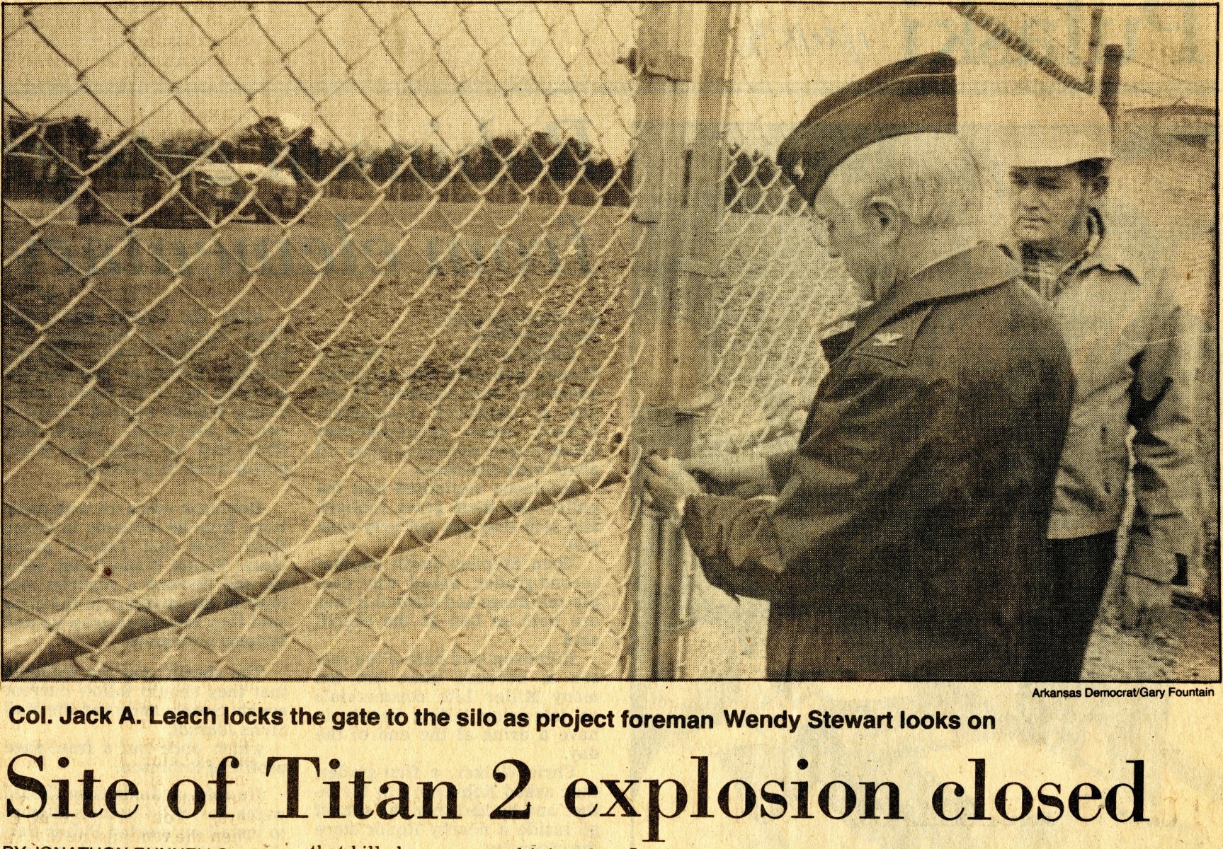Newspaper photograph: Col. Jack A. Leach locks the gate to the silo as project foreman Wendy Stewart looks on. The headline reads, " Site of Titan 2 explosion closed."